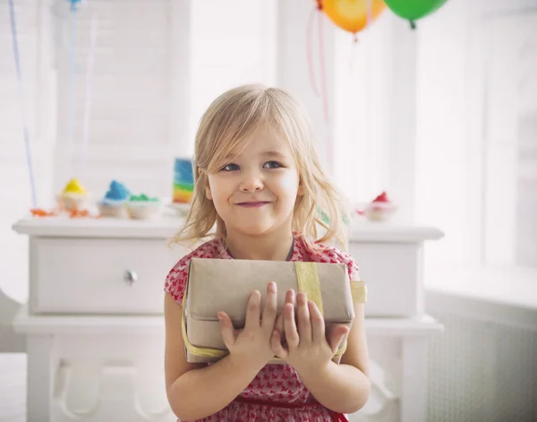 Glückliches kleines Mädchen mit Geschenk feiert ihren Geburtstag — Stockfoto