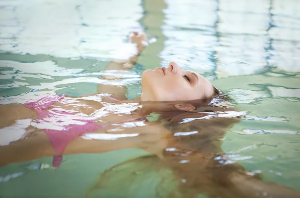 Ung blond kvinna avkopplande i vattnet — Stockfoto