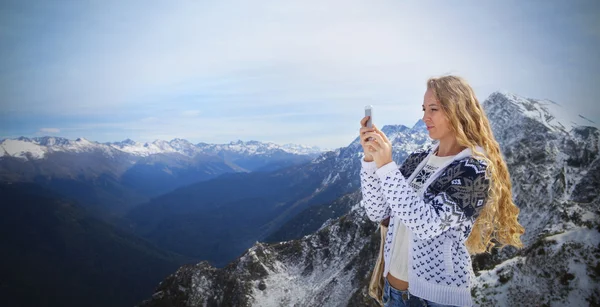 Blond woman photographing winter landscape mountains — Stock Photo, Image