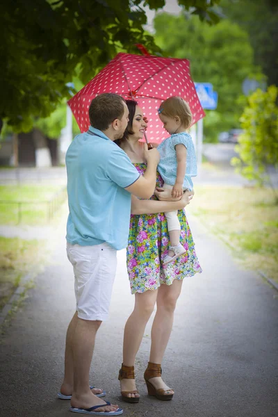 Jonge gelukkige familie onder paraplu — Stockfoto