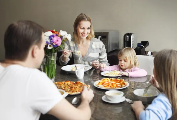 Famille riant autour d'un bon repas dans la cuisine — Photo