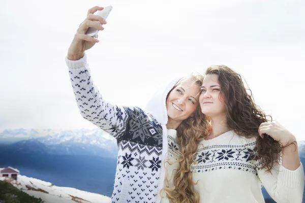 Szczęśliwy siostry fotografowanie selfie w ferie zimowe — Zdjęcie stockowe