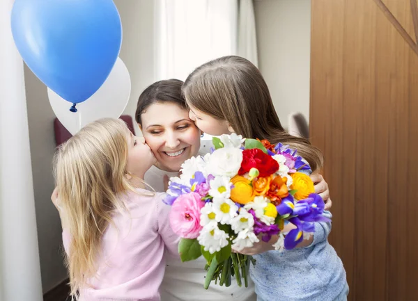 Счастливая женщина и ее маленькие дочери в гостиной — стоковое фото