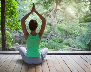 Genç kadının akşam Yoga asana yapması 