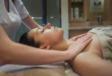 Yetişkin bir kadının yüz masajı yapıyor masör 