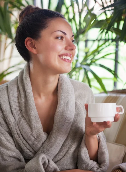 Молодая расслабленная женщина пьет чай на курорте — стоковое фото