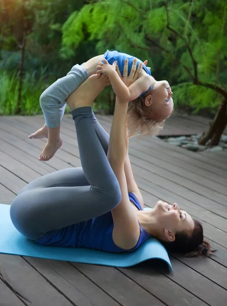Madre e hija haciendo ejercicio practicando yoga al aire libre —  Fotos de Stock