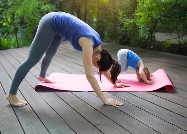 Mãe e filha fazendo exercício praticando ioga ao ar livre — Fotografia de Stock