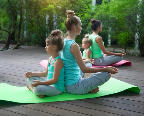 Mères et filles faisant de l'exercice pratiquant le yoga à l'extérieur — Photo