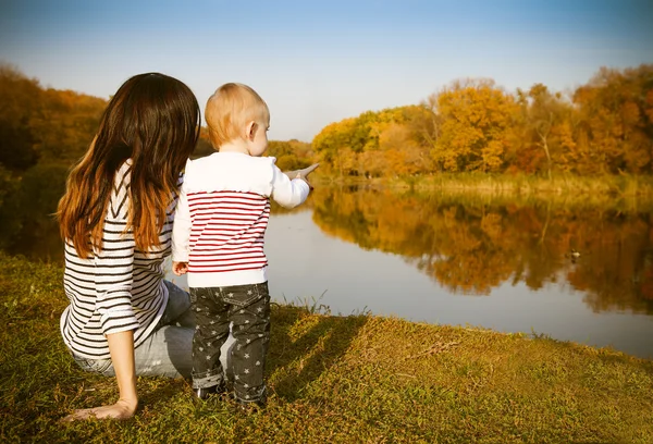 Mãe e bebê no lago de outono — Fotografia de Stock