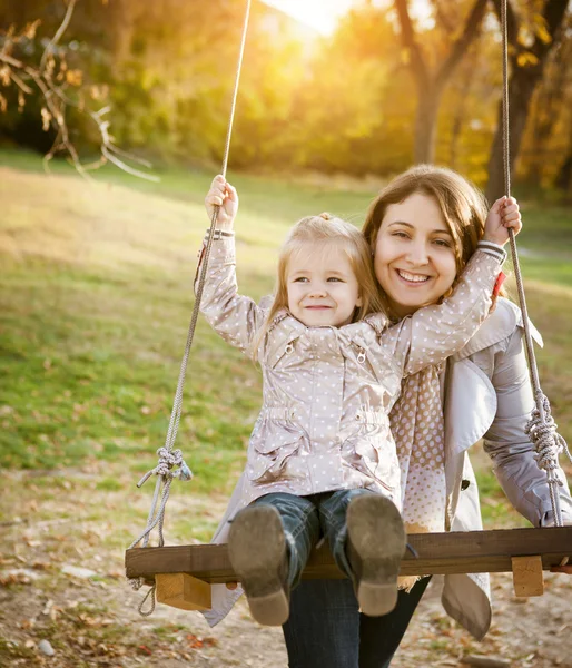 Šťastné matky a její malá dětská houpačka — Stock fotografie