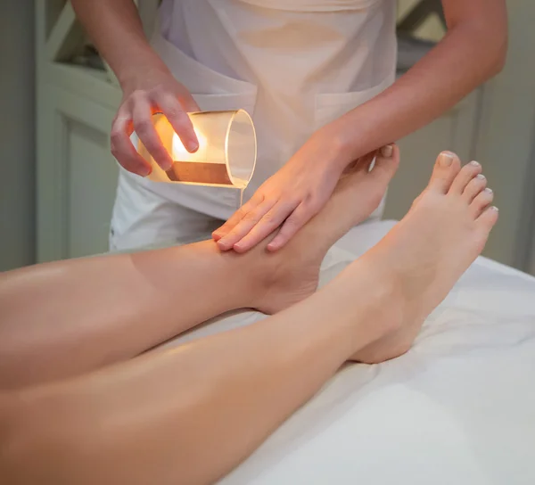 Mujer recibiendo masaje de spa con vela de masaje —  Fotos de Stock