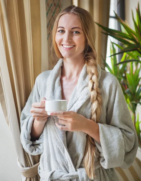 Молодая расслабленная женщина пьет чай на курорте — стоковое фото