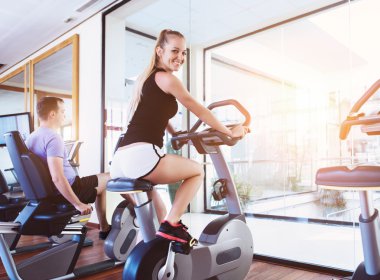 Bir spor merkezinde bir koşu bandı üzerinde sağlıklı çift eğitim