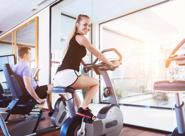 Bir spor merkezinde bir koşu bandı üzerinde sağlıklı çift eğitim