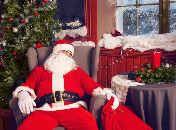 Фото счастливого Санта-Клауса с большим мешком подарков, спящего — стоковое фото