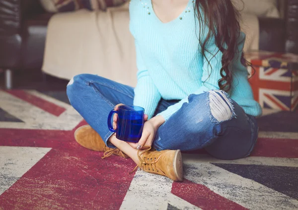 Vacker hipster tjej dricka te nära soffan — Stockfoto