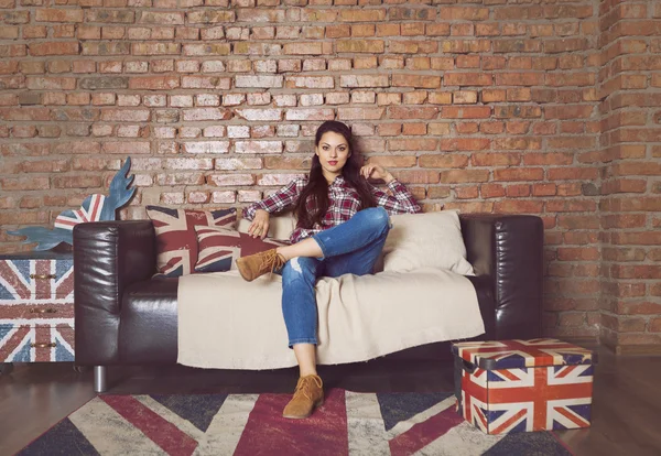 Pretty hipster girl sitting on couch at home — Stock Photo, Image