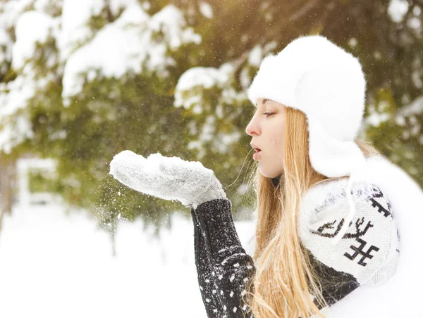 Vacker blond kvinna blåser snö utomhus — Stockfoto