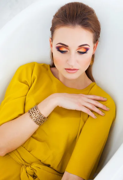 Vacker flicka med make up bär långa gula klänning — Stockfoto