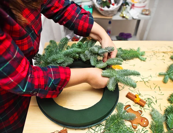 Woman spinning and decorating Christmas wreath — Stock Photo, Image