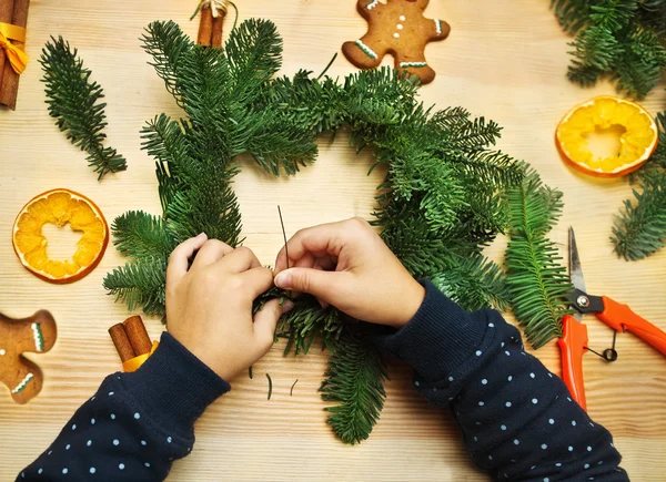 Little girl spinning and decorating Christmas wreath — Stock Photo, Image