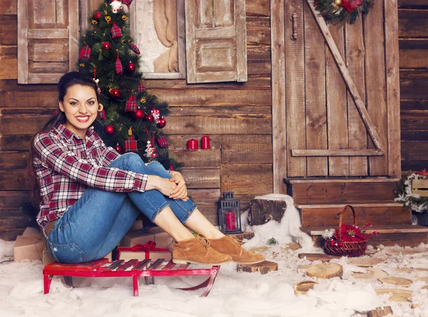 Pretty woman sitting near the Christmas tree — Stock Photo, Image