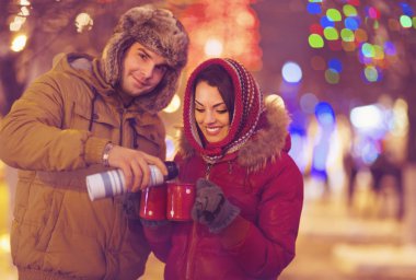 Bulanık ışıklar arka plan üzerinde çay içme mutlu genç Çift