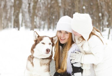 Mutlu anne ile kızı ile dış yapraklar köpek kış parkta