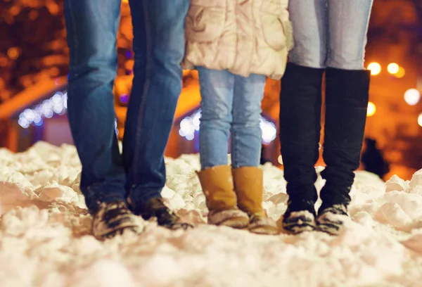 Los pies de una familia con zapatos de invierno en la nieve sobre Christma —  Fotos de Stock