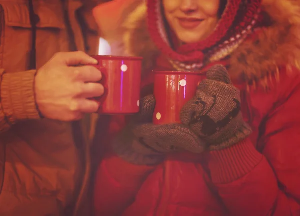 Gelukkig jonge paar drinken thee op de achtergrond wazig lights — Stockfoto