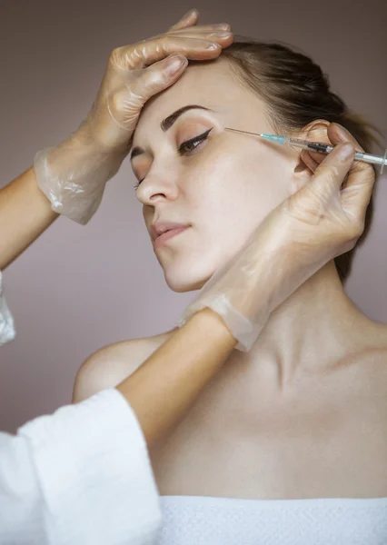 Mujer bonita joven recibiendo inyección cosmética en la cara como un — Foto de Stock