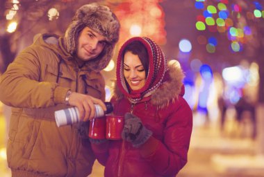 Bulanık ışıklar arka plan üzerinde çay içme mutlu genç Çift