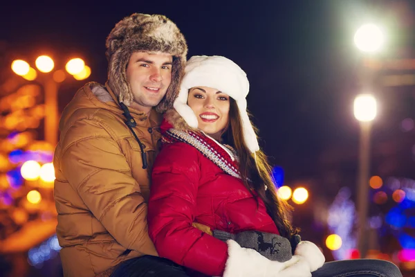 Pareja feliz enamorada al aire libre en las luces de Navidad — Foto de Stock