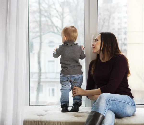 Mother and daughter near the window at home — Stock Photo, Image