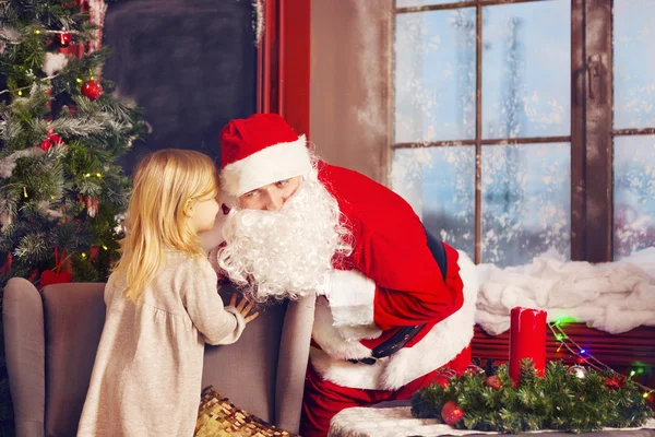 Little girl telling her Christmas wish in Santa Claus near the C — Stock Photo, Image
