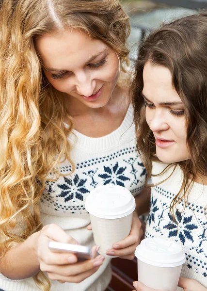 Dos amigas felices compartiendo redes sociales en un teléfono inteligente o —  Fotos de Stock