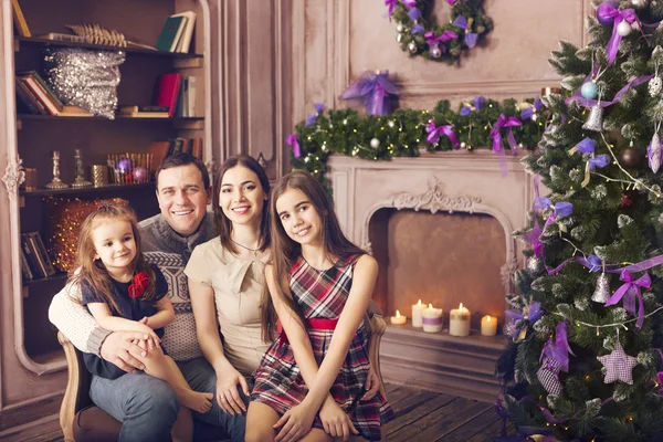 Elegante familia celebrando la Navidad en la habitación sobre el árbol de Navidad —  Fotos de Stock