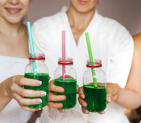 Young happy female friends drinking juice in spa and have fun — Stock Photo, Image