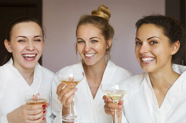 Young happy female friends drinking champagne in spa — Stock Photo, Image
