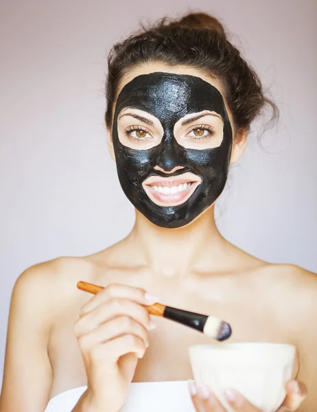 Giovane donna che applica una maschera per il viso del blac terapeutico — Foto Stock