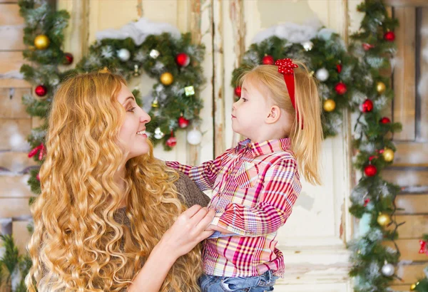 Mãe feliz e sua filha bebê pelas decorações de Natal — Fotografia de Stock