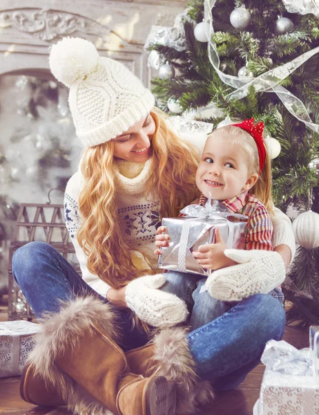 Mãe feliz e sua filha bebê pela árvore de Natal — Fotografia de Stock