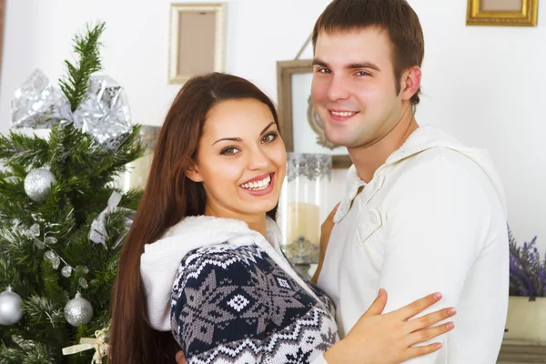 Joven pareja feliz junto al árbol de Navidad — Foto de Stock