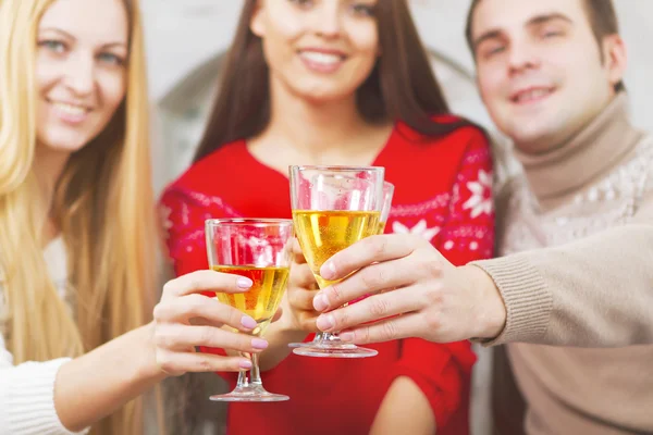 Felices amigos sonrientes bebiendo champán junto al árbol de Navidad — Foto de Stock