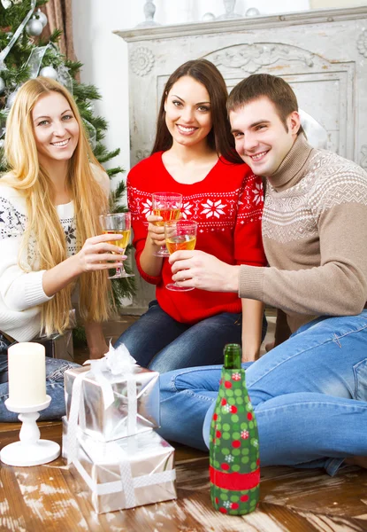 Happy usmívající se přátelé pití šampaňského Cristmas strom — Stock fotografie