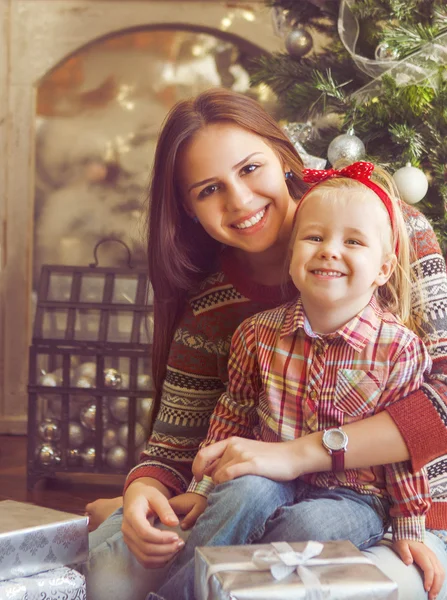 Two happy sisters sitting by the Christmas tree — Stock Photo, Image