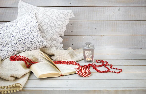 Натюрморт с фонариком, конфеты, книги и красные бусины — стоковое фото