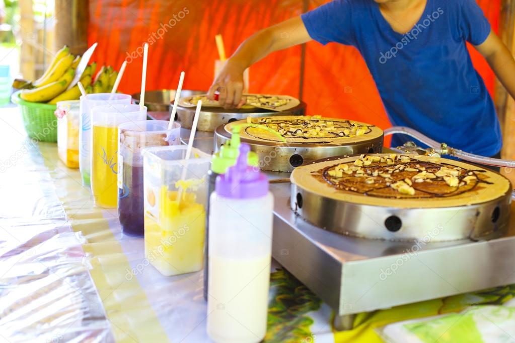 Woman cooking traditinal Thai Banana Pancake with chocolate