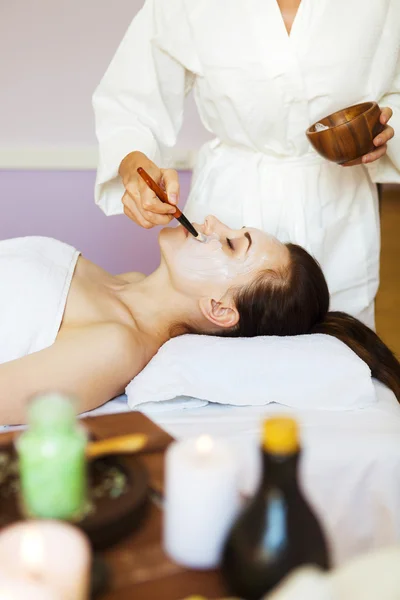 Jonge vrouw in een masker voor het gezicht van de therapeutische witte modder. — Stockfoto